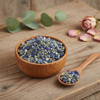 Grains d'encens de résine Vierge Marie, mélange de teintes bleu saphir et gris-vert pâle, dans un bol en bois clair avec cuillère, sur une planche de bois rustique.