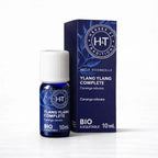Un flacon de 10 ml et son emballage d'huile essentielle d'Ylang-Ylang Complète (Bio & Équitable) de la marque Herbes & Traditions, présentés sur un fond blanc épuré.