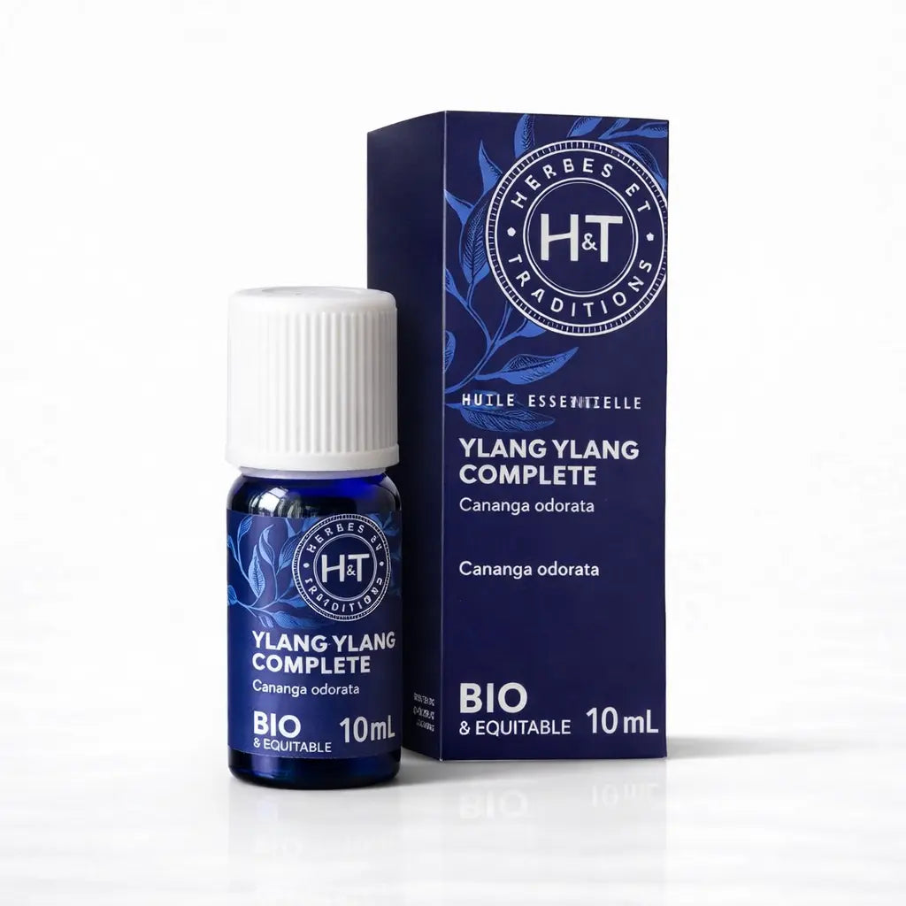 Un flacon de 10 ml et son emballage d'huile essentielle d'Ylang-Ylang Complète (Bio & Équitable) de la marque Herbes & Traditions, présentés sur un fond blanc épuré.